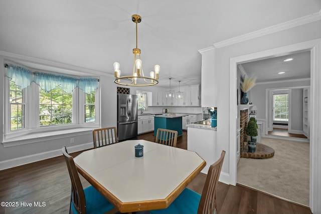 dining room with dark wood-style floors, baseboards, an inviting chandelier, and ornamental molding