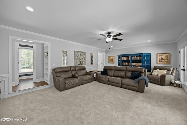 carpeted living room with crown molding, built in features, a ceiling fan, and recessed lighting