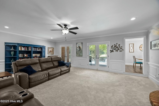 carpeted living area with french doors, ceiling fan, recessed lighting, and a decorative wall