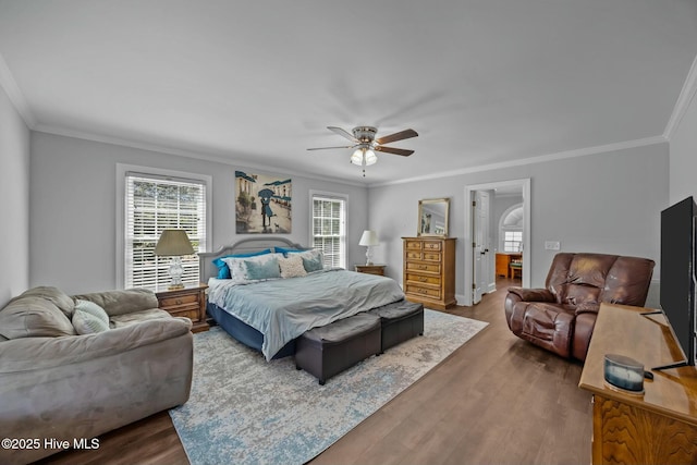 bedroom with crown molding, wood finished floors, ceiling fan, and baseboards
