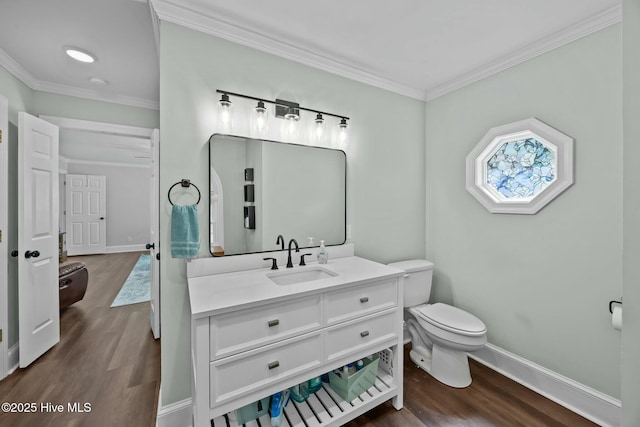 bathroom with toilet, wood finished floors, and ornamental molding