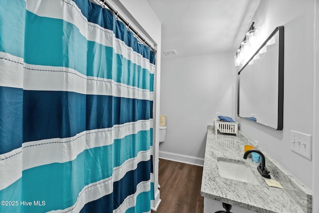 full bathroom with visible vents, baseboards, a shower with shower curtain, vanity, and wood finished floors