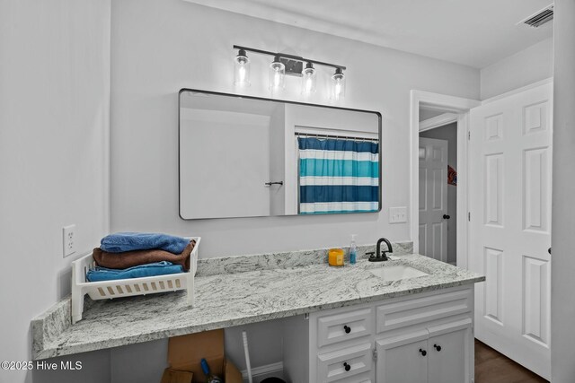 bathroom with a shower with shower curtain, vanity, and visible vents