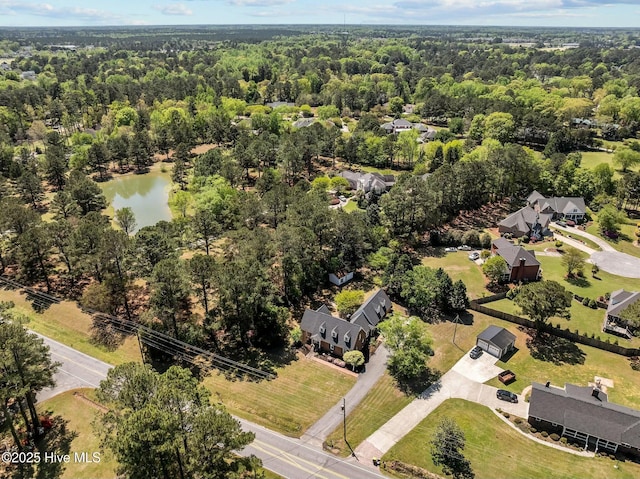 birds eye view of property featuring a water view and a view of trees