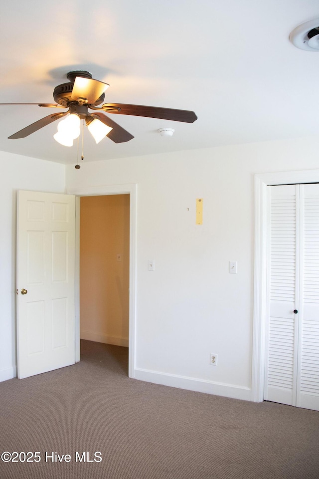 unfurnished bedroom featuring baseboards, a closet, a ceiling fan, and carpet floors
