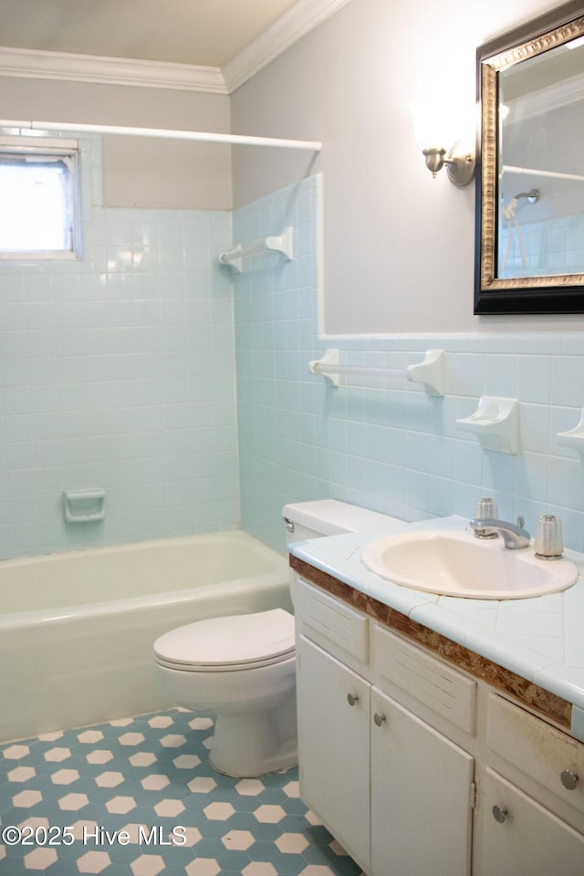 full bath featuring vanity, ornamental molding, toilet, shower / bathing tub combination, and tile walls