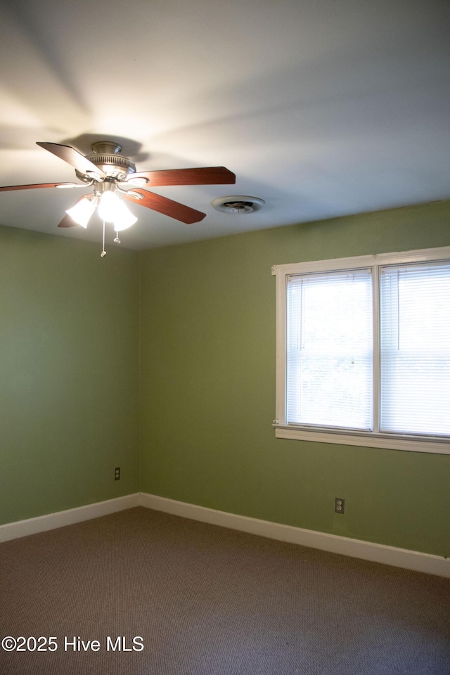 spare room with visible vents, ceiling fan, carpet flooring, and baseboards