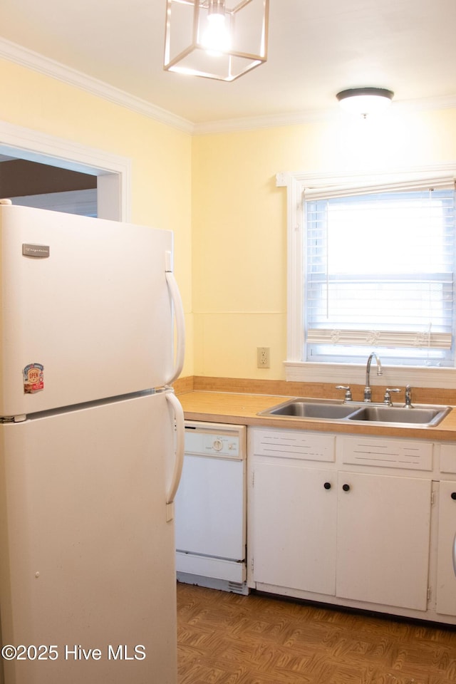 kitchen featuring crown molding, white appliances, white cabinetry, light countertops, and a sink