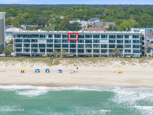 aerial view of waterfront with a beach and apartment complex