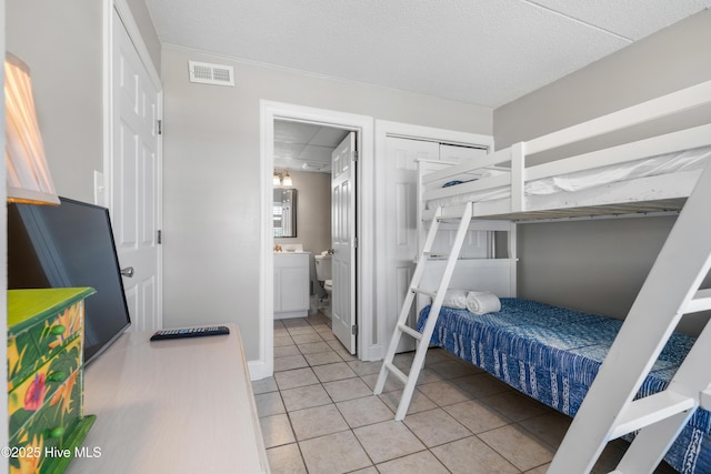 bedroom with light tile patterned flooring and connected bathroom