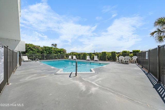 community pool with fence and a patio area