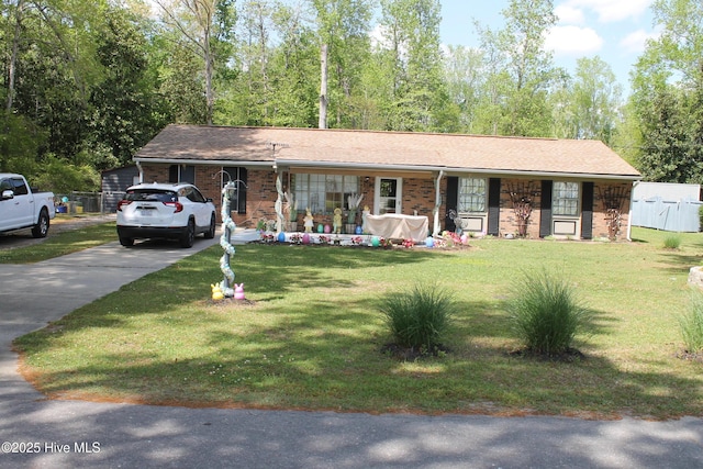 single story home featuring a front yard, brick siding, and driveway