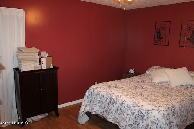 bedroom with baseboards and wood finished floors