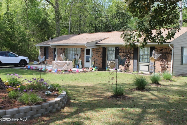 ranch-style house featuring covered porch, a front lawn, and brick siding