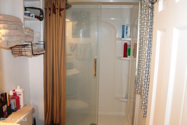 bathroom featuring a shower stall and toilet