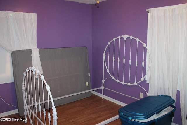 bedroom featuring baseboards and wood finished floors