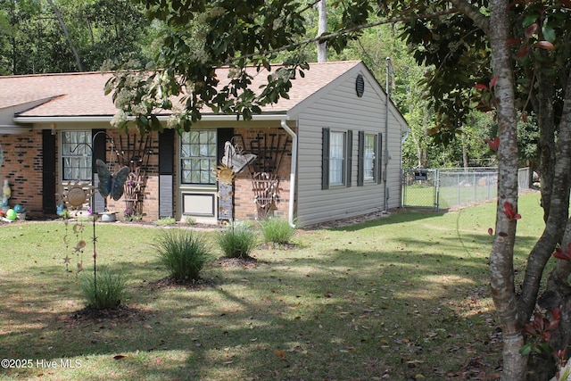 single story home featuring fence, a front yard, a gate, and a shingled roof