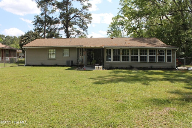 rear view of property with central air condition unit, a yard, a patio area, and fence