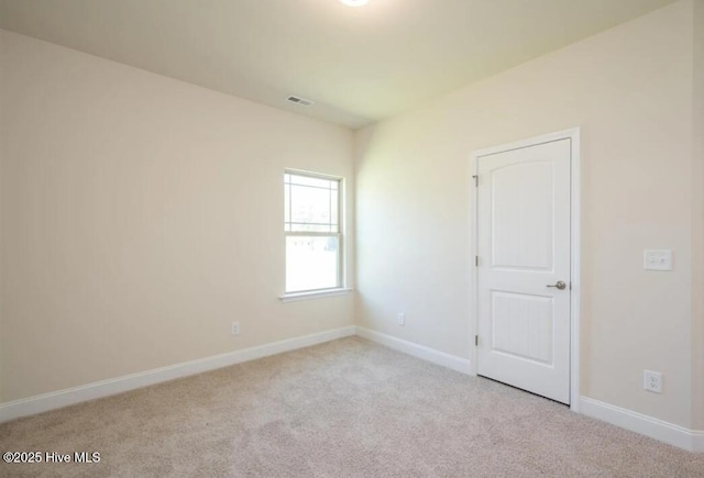 carpeted empty room with visible vents and baseboards