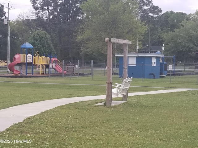 view of community with a yard, fence, and playground community