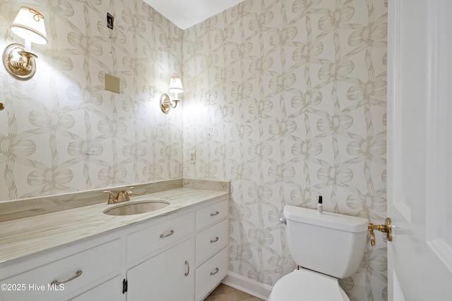 half bathroom with baseboards, wallpapered walls, toilet, and vanity