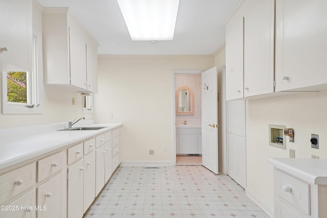 washroom featuring hookup for an electric dryer, washer hookup, a sink, cabinet space, and light floors