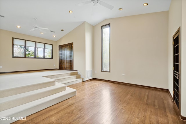 interior space featuring a ceiling fan, visible vents, and a wealth of natural light