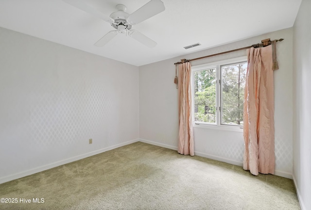 empty room with baseboards, visible vents, ceiling fan, and carpet floors