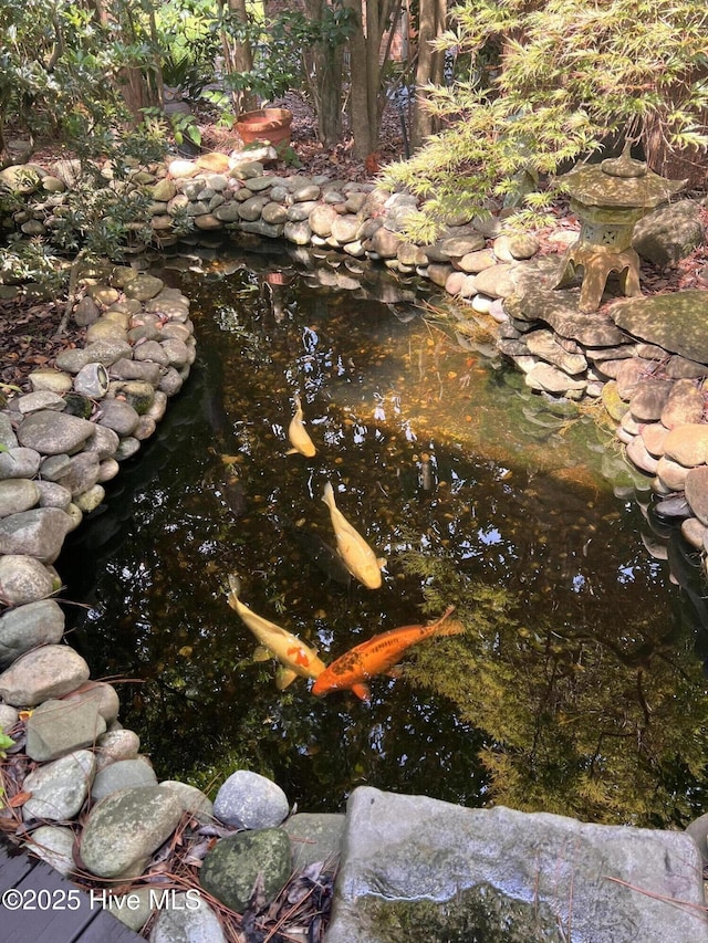 exterior details with a garden pond