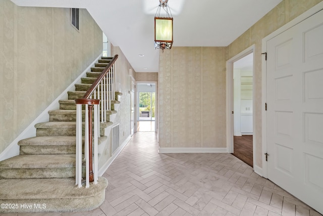 entryway featuring visible vents, baseboards, and stairs