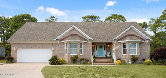 3378 Willow Cir SE, Southport, NC 28461 - view of front facade featuring driveway, a garage, brick siding, a front lawn, and a shingled roof