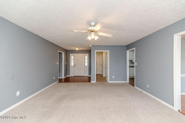 carpeted entryway with baseboards, a ceiling fan, and a textured ceiling