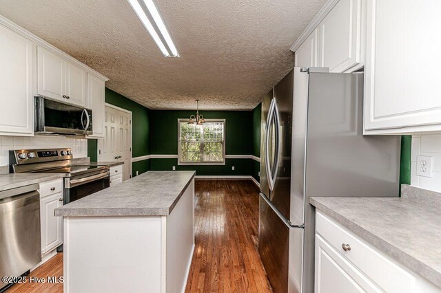 kitchen with white cabinets, dark wood-type flooring, and appliances with stainless steel finishes