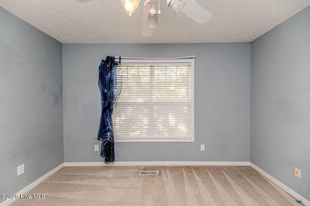 unfurnished room featuring a textured ceiling, a ceiling fan, visible vents, and carpet floors