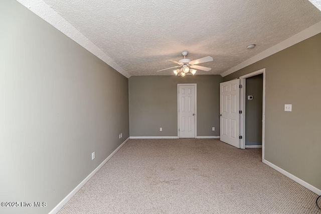 spare room featuring a textured ceiling, baseboards, a ceiling fan, and carpet