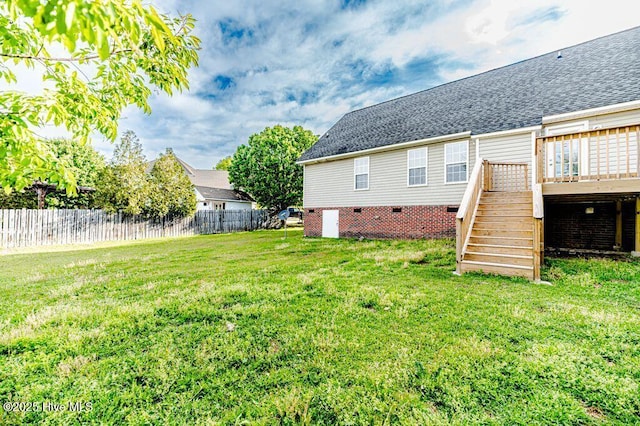 back of property featuring crawl space, stairs, a wooden deck, fence, and a lawn