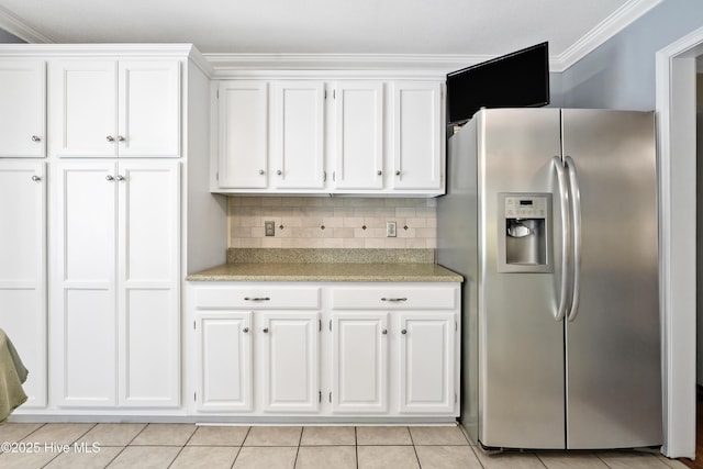 kitchen featuring decorative backsplash, crown molding, white cabinets, stainless steel fridge, and light tile patterned flooring