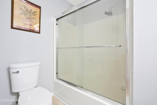 bathroom featuring baseboards, toilet, and shower / bath combination with glass door