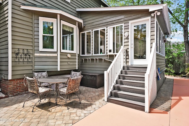 view of patio featuring outdoor dining space and entry steps
