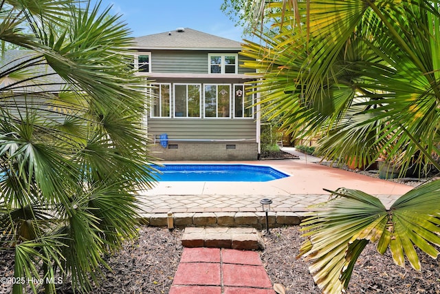 outdoor pool with a sunroom and a patio