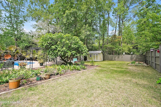 view of yard with a storage unit, a fenced backyard, an outbuilding, and a fenced in pool