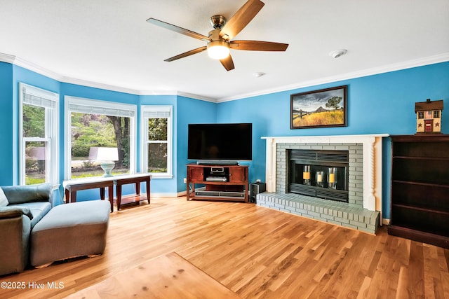 living area with crown molding, ceiling fan, and wood finished floors