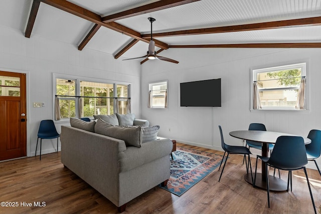 living area with dark wood-style floors, vaulted ceiling with beams, and a wealth of natural light