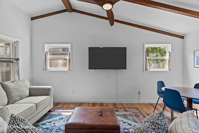 living area with lofted ceiling with beams and wood finished floors