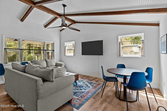 living room featuring lofted ceiling with beams, ceiling fan, wood finished floors, and plenty of natural light