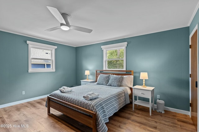 bedroom featuring wood finished floors, ceiling fan, ornamental molding, and baseboards
