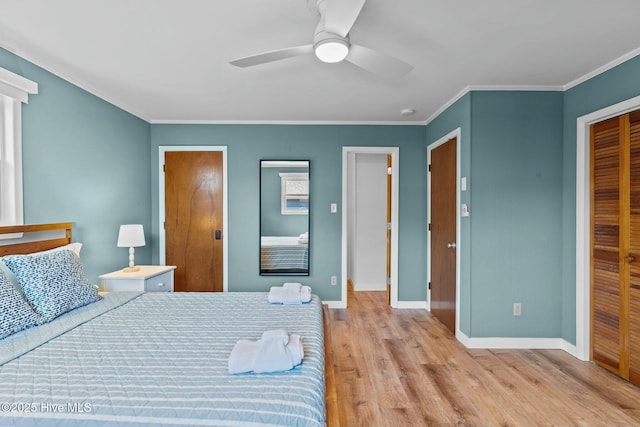 bedroom with a closet, a ceiling fan, baseboards, ornamental molding, and wood finished floors