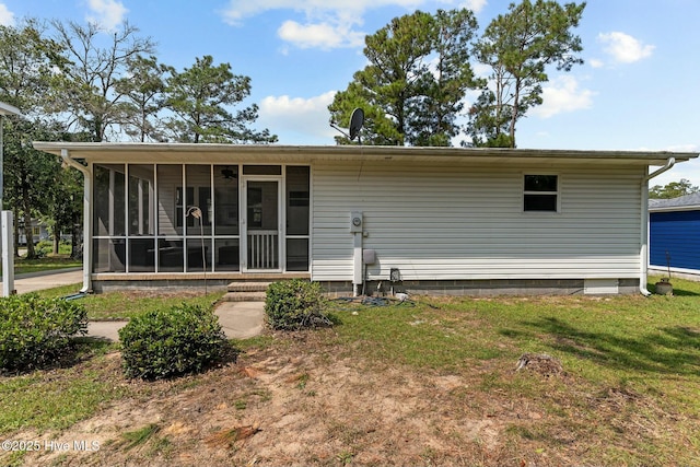 back of property featuring a lawn and a sunroom