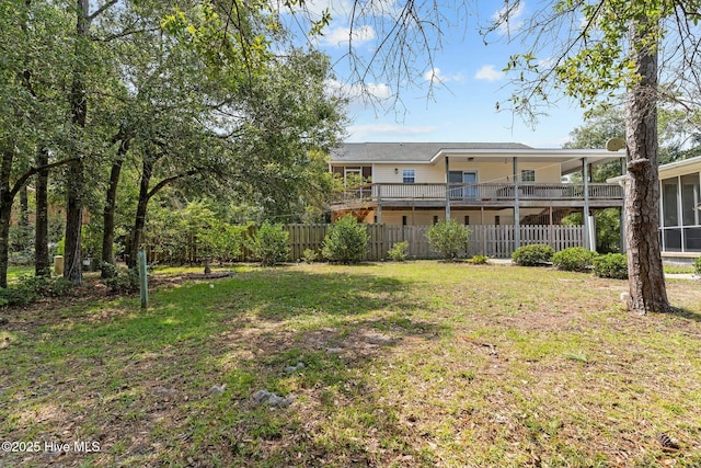 view of yard with fence and a sunroom