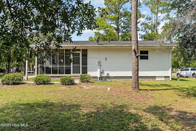 back of house with a yard and a sunroom